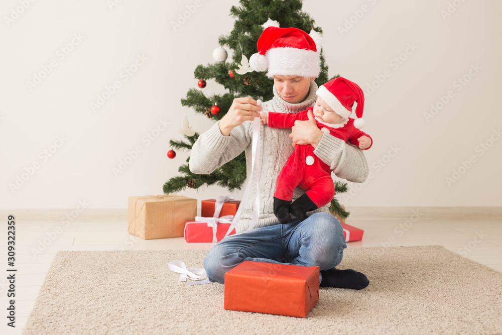 Father with his baby boy wearing Santa hats celebrating Christmas. Father with his baby boy wearing Santa hats celebrating Christmas.