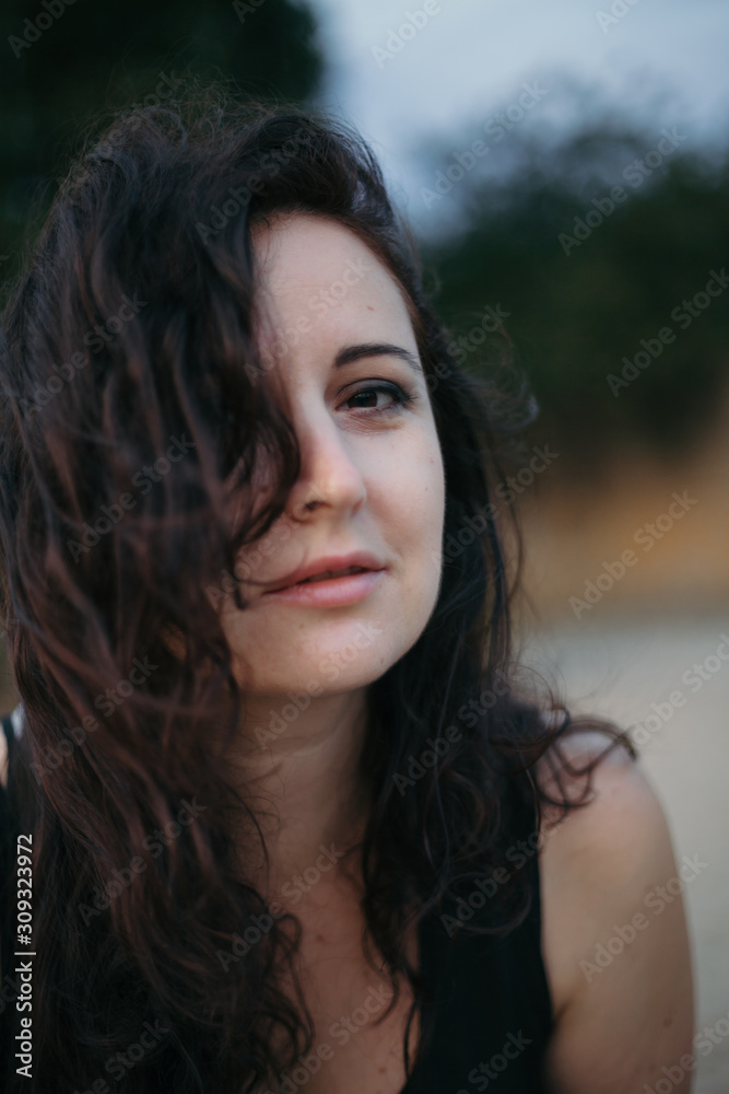 Beautiful brown-haired woman in  black T-shirt on  blurred background