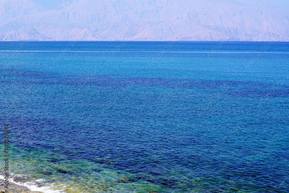 sea and blue sky by Hajar mountains in Fujairah