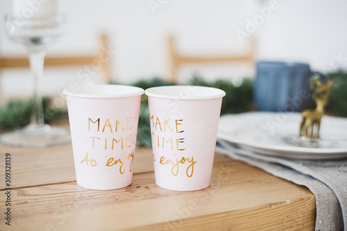 Cups with a message for the new year and Christmas, drinks in a glass, the interior of the house