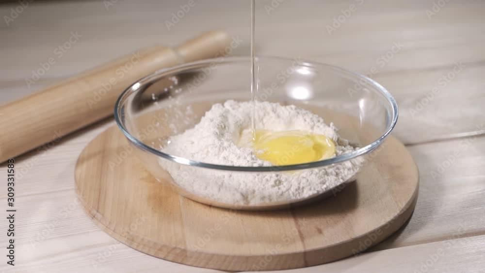 Slow motion of falling eggs into flour stock. Footage food. Egg dropping into flour, slow motion. Slow motion of falling eggs into flour stock. Footage food. Egg dropping into flour, slow motion.