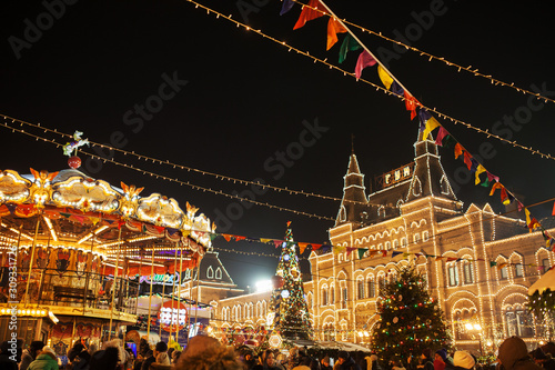 Celebration lights and decorations on Red Square for festive Christmas and New Year. Shining yellow lights on facade GUM in Moscow, Russia. Night cityscape of Moscow