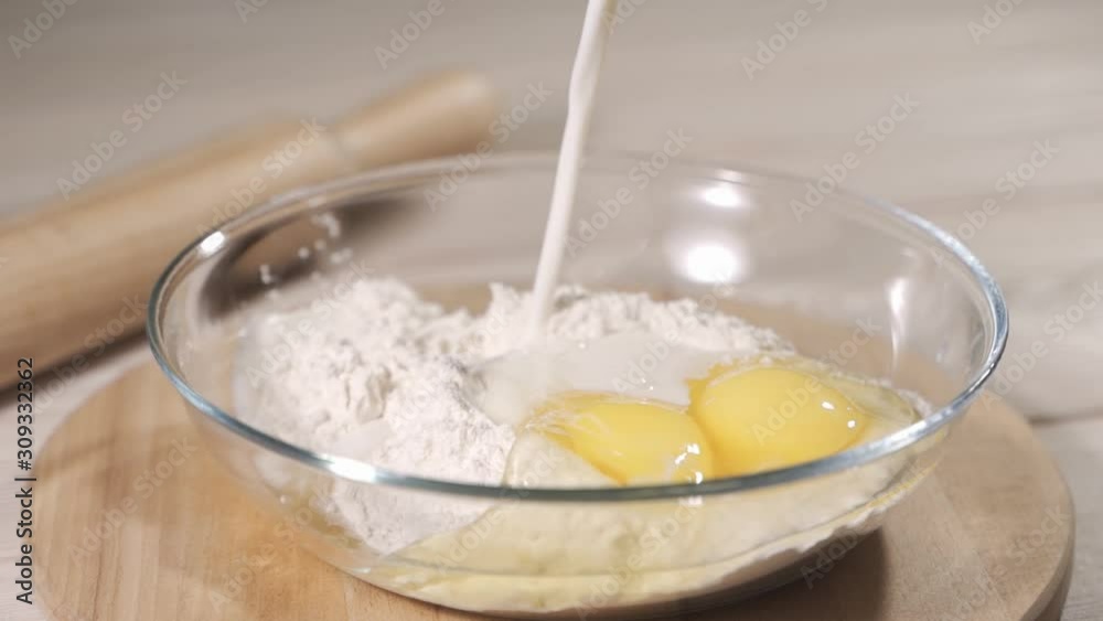 Adding milk to flour and egg Adding milk to flour and egg
