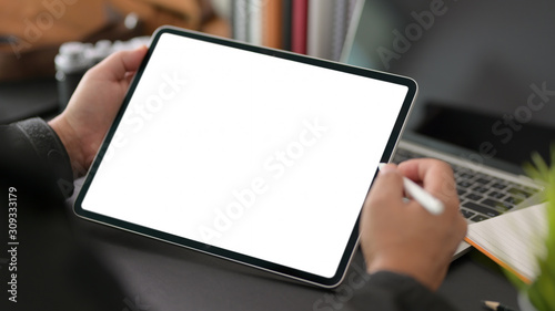 Cropped shot of young businessman using blank screen digital tablet in modern office