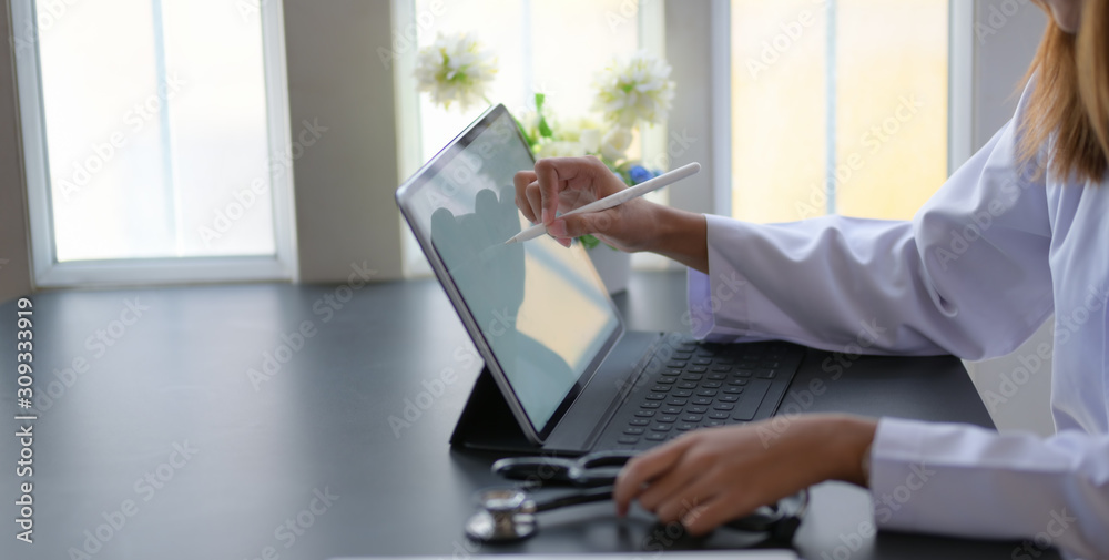 Cropped shot of young female doctor working on medical expertise with tablet in modern office Cropped shot of young female doctor working on medical expertise with tablet in modern office