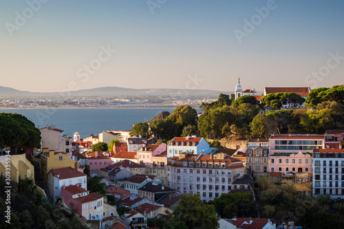 Scenic view of the Tagus River, Church Santa Cruz do Castelo and old buildings at the Alfama district in downtown Lisbon, Portugal. Viewed from the Miradouro da Senhora do Monte viewpoint.
