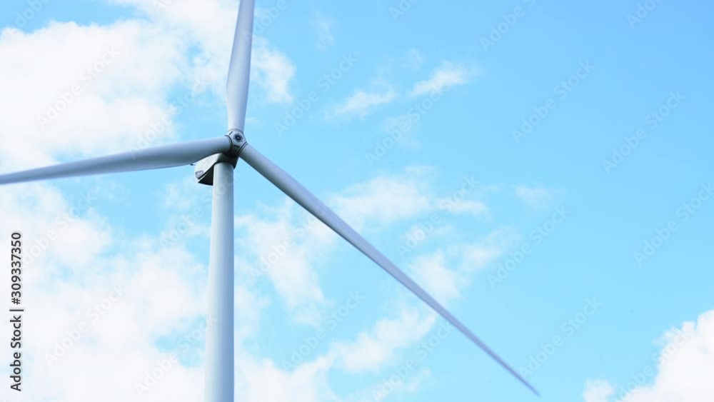 Detail of wind turbine blades spinning in the wind with summer blue sky background Detail of wind turbine blades spinning in the wind with summer blue sky background
