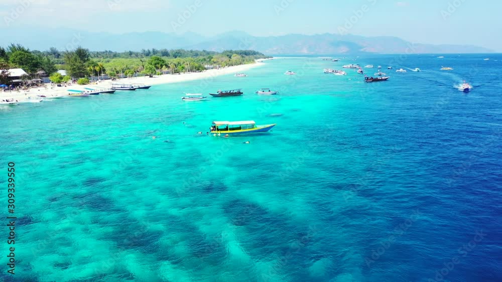 Paradise tropical bay of tropical island with white sandy beach where many people sunbathing, washed by blue azure lagoon full of Thai boats Paradise tropical bay of tropical island with white sandy beach where many people sunbathing, washed by blue azure lagoon full of Thai boats