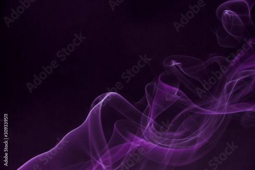 Mystic smoke patterns moving in colour on black background.