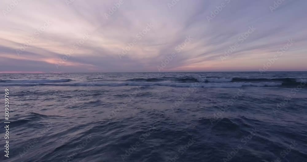 An aesthetic drone flight over the blue water on a beautiful summer evening during a sunset. An aesthetic drone flight over the blue water on a beautiful summer evening during a sunset.