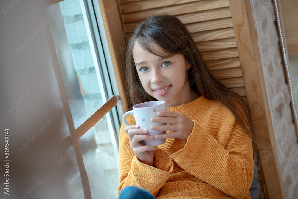 Pretty gor with cup in her hands looking hapy Pretty gor with cup in her hands looking hapy