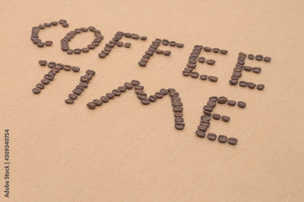 coffee time design spelled with arabica coffee beans on sandy background