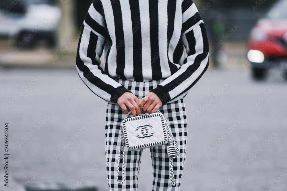 Paris France March 5 2019 Street style Woman wearing black white striped jumper plaid pants and Chanel bag before a fashion show during Paris Fashion Week PFWFW19 foto de Stock Adobe Stock