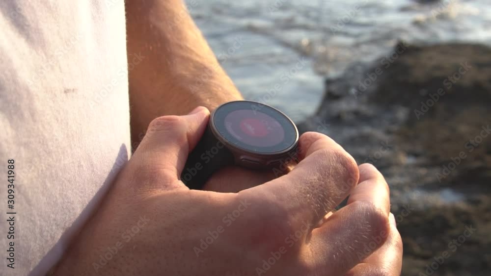 Adult fit man sets his training watch and starts Adult fit man sets his training watch and starts