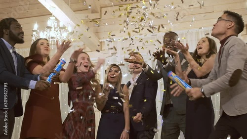 Happy company colleagues throw candy up. They have fun and celebrate the new year