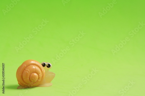 snail shaped plastic toy in color background