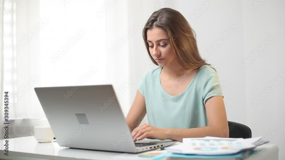 Portrait of a tired mixed race woman working on laptop in office. Headache in a girl at the workplace at the computer. Portrait of a tired mixed race woman working on laptop in office. Headache in a girl at the workplace at the computer.