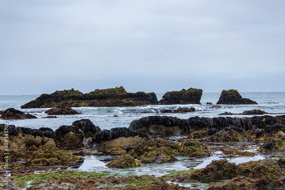 Tidal pools with ocean waves crashing over rocks Tidal pools with ocean waves crashing over rocks