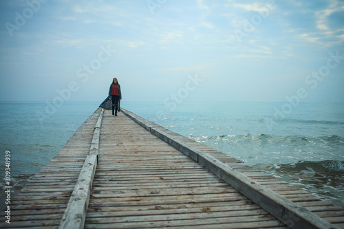 Young Girl Walking on the Pier to the Sea