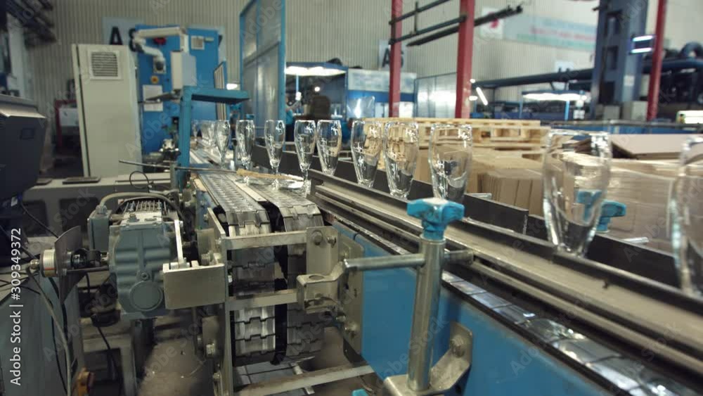 Automatic conveyor line or belt with rows of transparent crystal drink glasses in industrial factory. Automatic conveyor line or belt with rows of transparent crystal drink glasses in industrial factory.