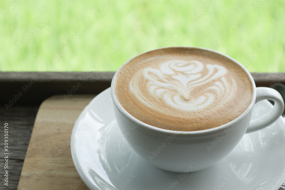 Coffee cup latte art in heart shape with a cup of dark coffee and dark chocolate on wooden table.Frothy drink for coffee break after working or weekend meeting Coffee cup latte art in heart shape with a cup of dark coffee and dark chocolate on wooden table.Frothy drink for coffee break after working or weekend meeting