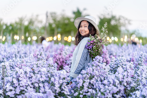 Pretty girl in a garden of flowers, Happy asian girl holding flower bouquet on Margaret Aster flowers field in garden at Chiang Mai, Thailand
