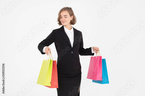 Portrait of young business woman holding shopping bags on white isolated background.