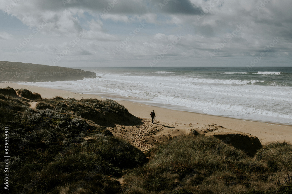 Rear view of man walking on beach in Portugal