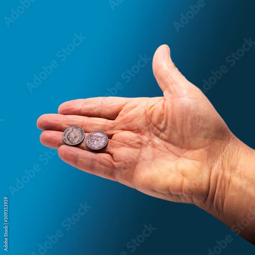 hand holding out two old coins