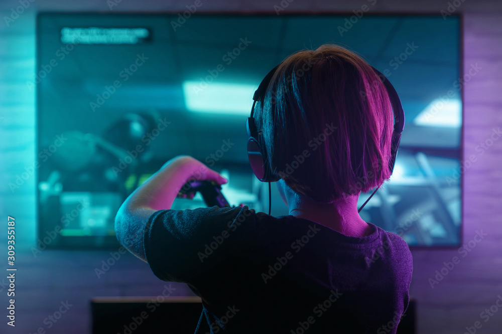 Little boy playing video game in the dark room Little boy playing video game in the dark room
