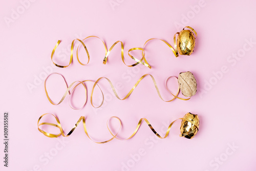 Three Bright Golden Gift Ribbons on Pink Background Holidays Festive Flat Lay Top View Minimal Concept Horizontal