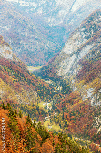 Top view of the valley in Slovenian Alps in autumn season with colorful trees on the slopes