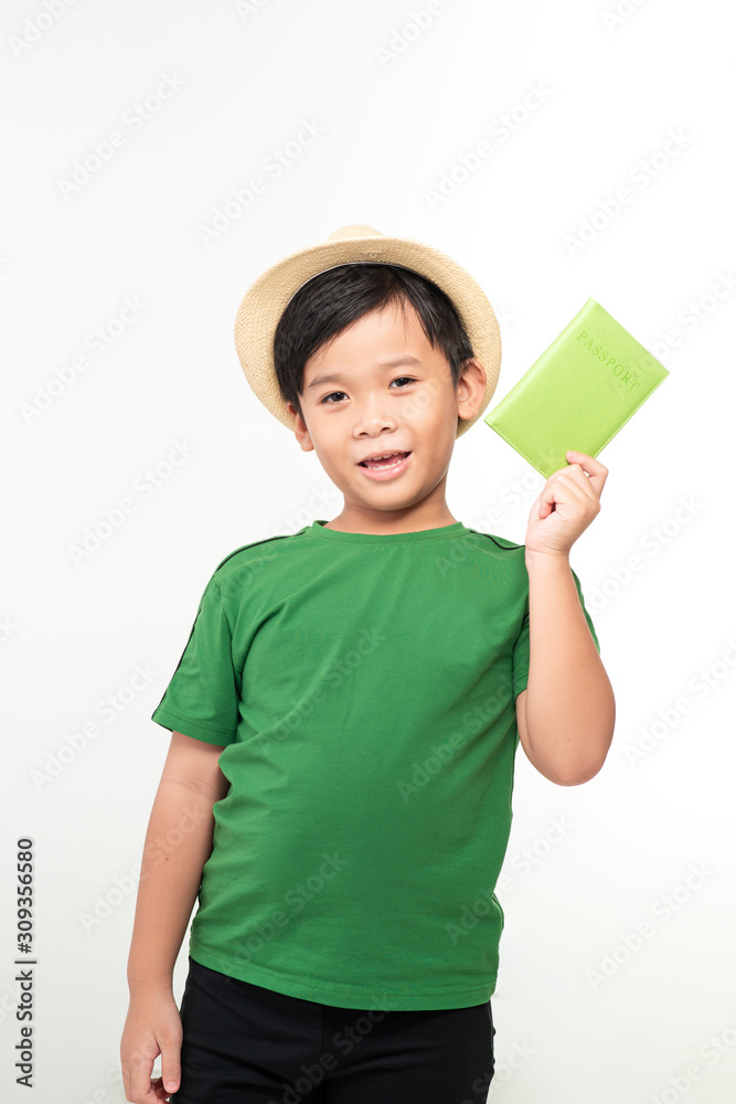 Handsome school age boy holding passport looking at camera wearing straw hat isolated on white background Handsome school age boy holding passport looking at camera wearing straw hat isolated on white background
