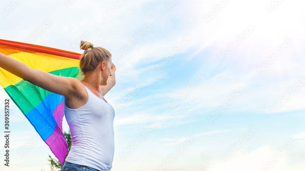 Woman Waving Rainbow Flag at Gay Parade. Young woman with a rainbow flag. Lesbian Girl Holding LGBT Flag. Female is holding the gay rainbow flag Woman Waving Rainbow Flag at Gay Parade. Young woman with a rainbow flag. Lesbian Girl Holding LGBT Flag. Female is holding the gay rainbow flag