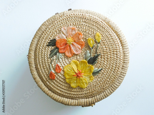vue du dessus d'un couvercle rond d'un joli panier de paille avec fleurs en raphia, décoration printemps et pâques