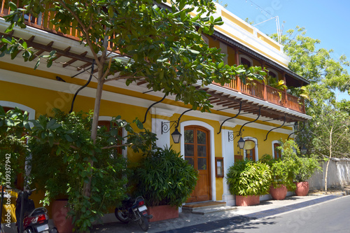 Yellow bright building with lanterns in the french colony in Pondicherry, sunny day and blue sky in Tamil nadu, India. photo