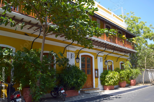 Yellow bright building with lanterns in the french colony in Pondicherry, sunny day and blue sky in Tamil nadu, India.