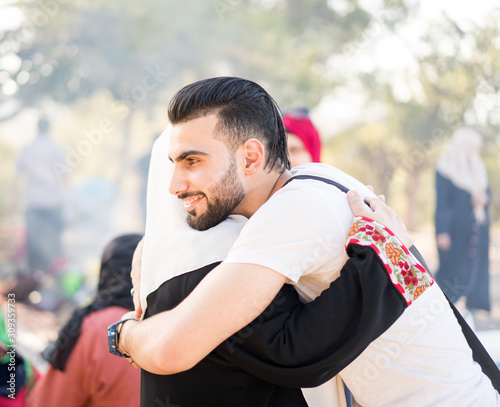 Muslim young man hugging his mother