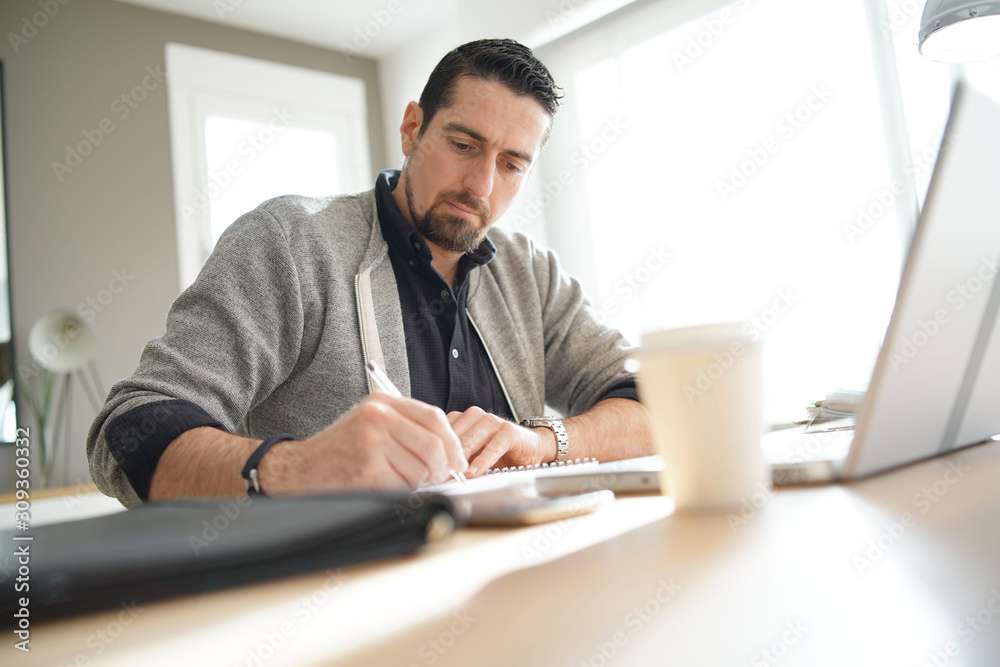 Man using laptop computer in co-working office Man using laptop computer in co-working office