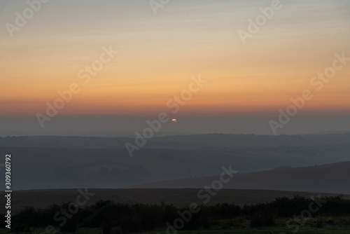 the red and orange sky at sunset over a hazy Exmoor