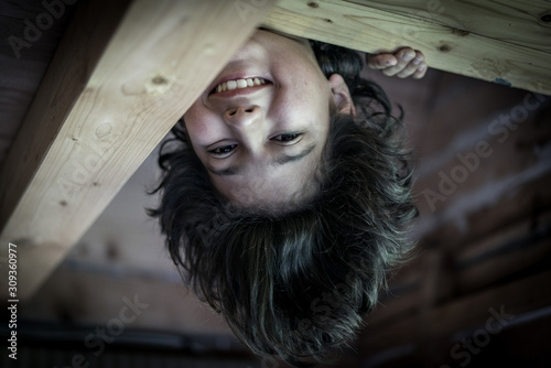 Upside down boy in wooden cottage