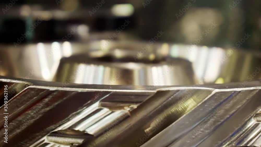 large shiny metal gear rotates slowly.Abstract moving background for your design.shallow depth of field.