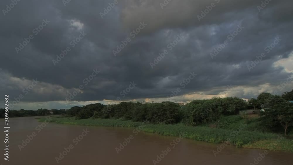 Vdo. view panning of dark clouds moving and heavy raining above Mae Klong river around with green forest in rain storm background, sunset and raining at Ban Pong City, Ban Pong, Ratchaburi, Thailand. Vdo. view panning of dark clouds moving and heavy raining above Mae Klong river around with green forest in rain storm background, sunset and raining at Ban Pong City, Ban Pong, Ratchaburi, Thailand.