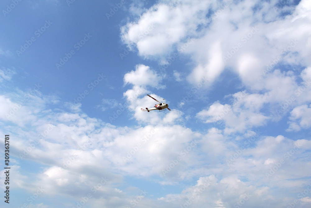 Helicopter aircraft model flying in the blue sky with clouds Helicopter aircraft model flying in the blue sky with clouds