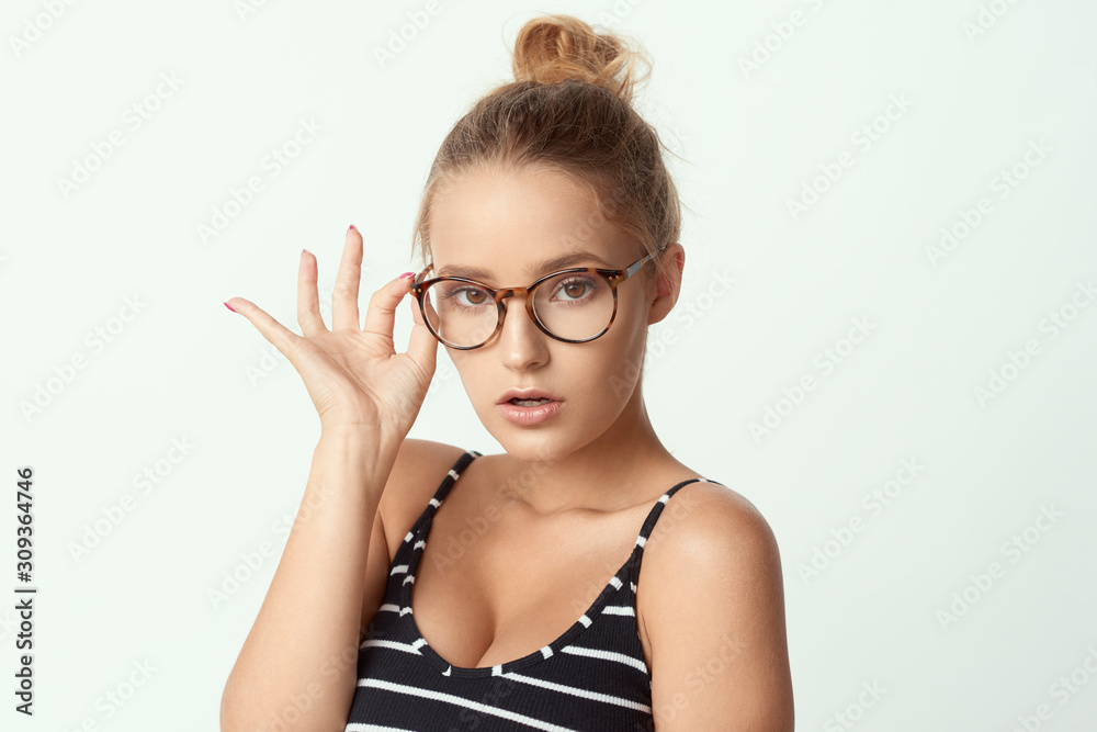 young girl in glasses, beautiful and healthy skin, natural blond hair, empty background, delicate makeup