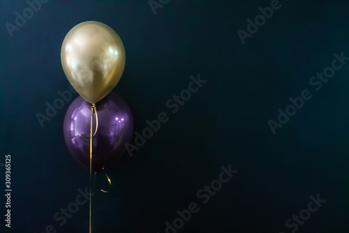 golden balloon and violet balloon on a dark background. Holiday Concept, Postcard