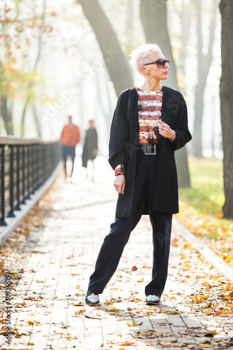 stylish blond woman in autumn park