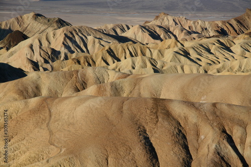 Zabriskie Point lookout over a surreal landscape of undulating ridges of gold, orange, and brown earth in Death Valley National Park and the Panamint Mountains photo