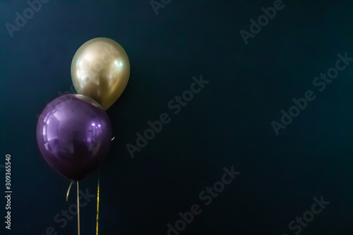 golden balloon and violet balloon on a dark background. Holiday Concept, Postcard