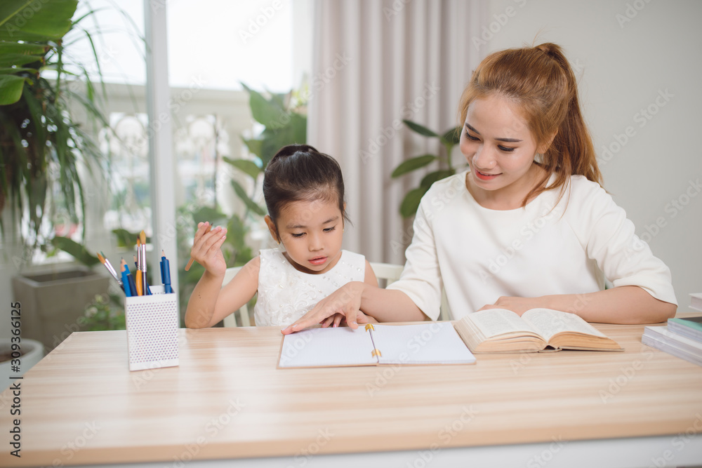 Mother helping her little child with homework Mother helping her little child with homework